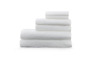 Snow - white Enso washcloths and hand towels stacked on top of our bamboo luxury towels